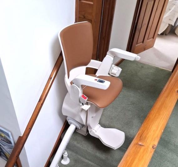 Otolift Modul air curved stairlift at the top of the staircase